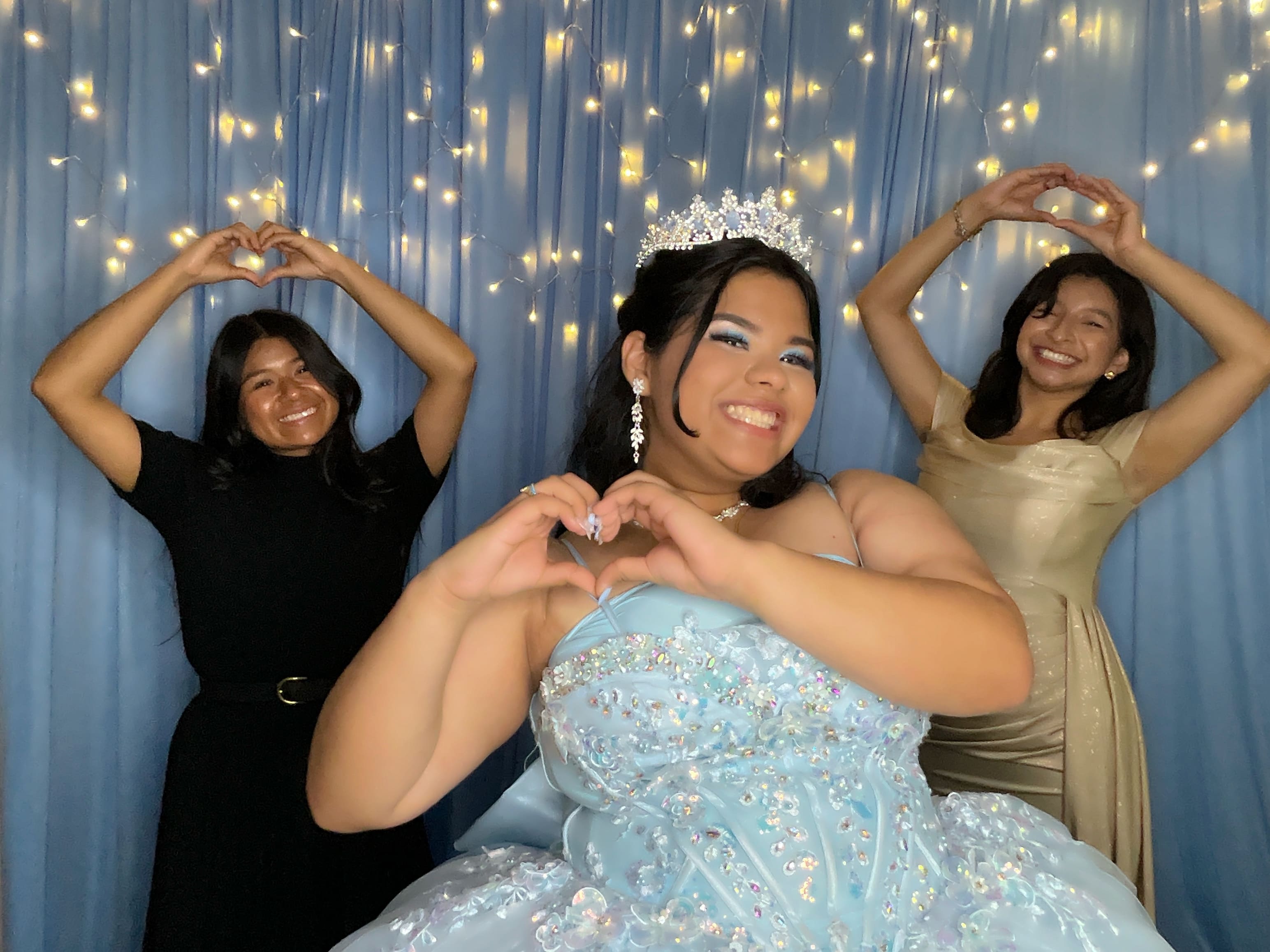 Quinceañera in light-blue gown with friends making heart hands — captured at a 360° Experience